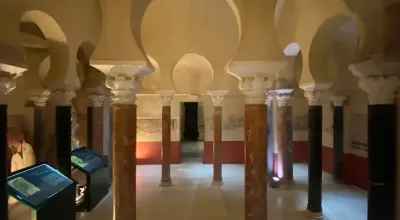 Vaulted interior of the Caliphal Baths in Córdoba showing star-shaped skylights and marble columns