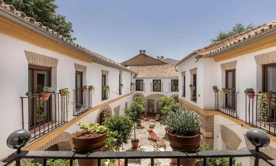 Flowery Andalusian patio with white columns at Cats Hostel in Córdoba