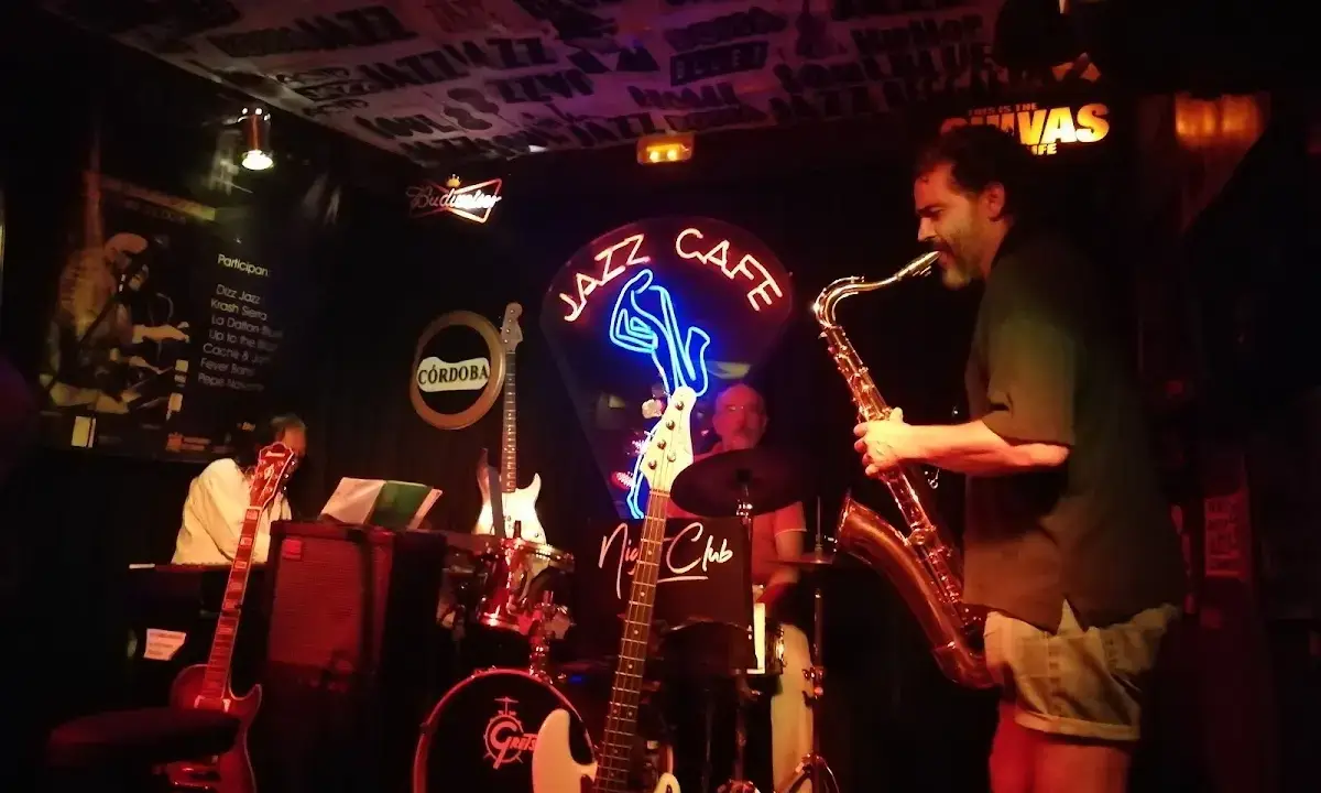 Intimate interior of Jazz Café with red lighting and vintage jazz posters