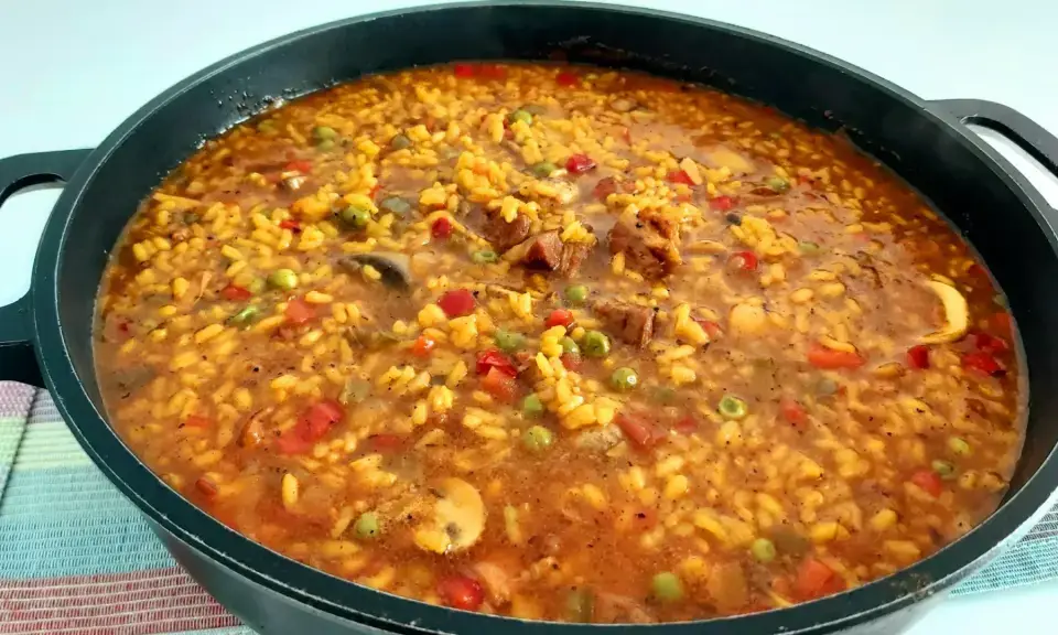 Large perol pan with rice dish cooking over open firewood fire in Córdoba countryside