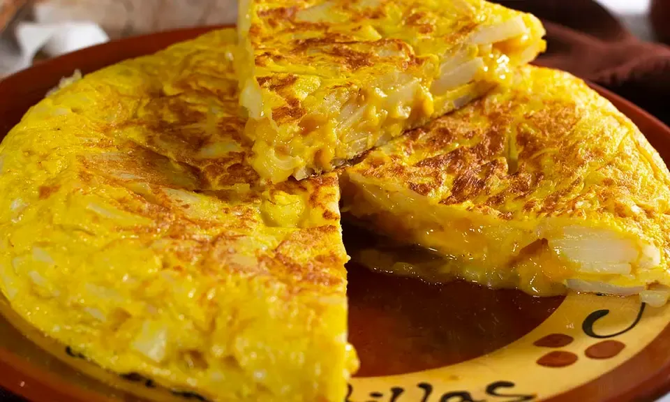 Thick slice of golden and creamy tortilla de patatas served on a plate