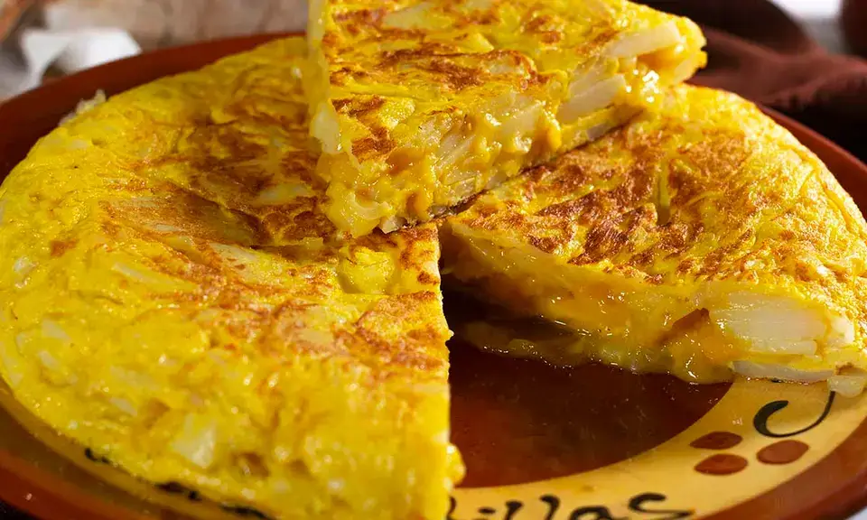 Thick slice of golden and creamy tortilla de patatas served on a plate